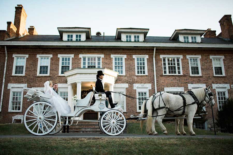 wedding coach with horses in front of the inn at forest oaks in virginia